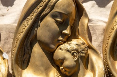 Jalon, Alicante - İspanya - 12-14-2024: Madonna ve çocuğun doğal güneş ışığıyla aydınlatılan karmaşık ayrıntılar ve çiçek desenleri içeren altın bir yardım heykeli.