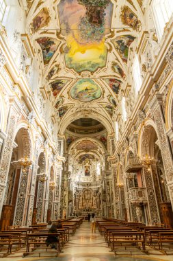 Palermo - Sizilien - Italien - 03-18-2025: Palermo 'daki Chiesa del Gesu' nun renkli tavan freskleri, karmaşık sıva duvarları ve altın ışıklı sıralarda sıralanmış bankları.