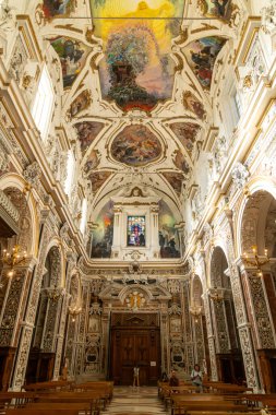 Palermo - Sizilien - Italien - 03-18-2025: Palermo 'nun içi Chiesa del Gesu' nun boyanmış tavanı, mermer sütunları, ahşap kapısı, boyalı camları ve oturan ziyaretçileri ile arka manzarası.