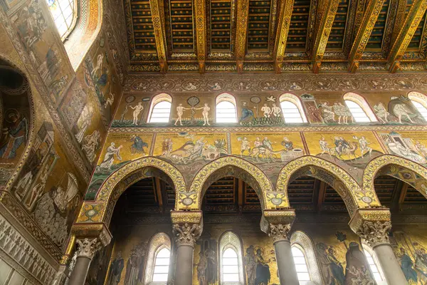 Monreale - Sizilien - Italien - 03-18-2025: Monreale Katedrali 'nin altın mozaikleri, kemerli sütunları ve kutsal kitapla kaplı tabut altındaki ahşap tavan manzaraları.