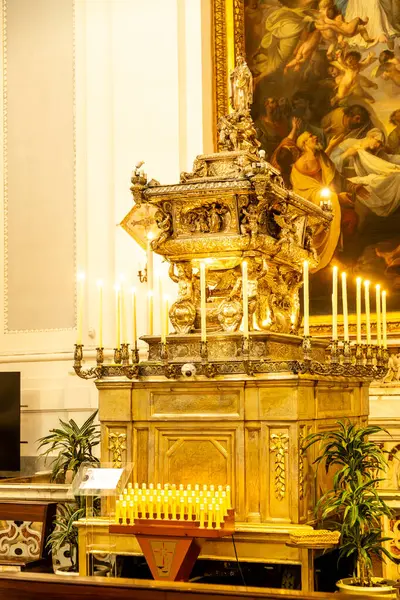 Palermo - Sizilien - Italien - 03-18-2025: Palermo Katedrali 'nde mum ışığında altın sunak, arka planda bir tablo ve ibadet edenler için modern bir elektrikli mum standı.