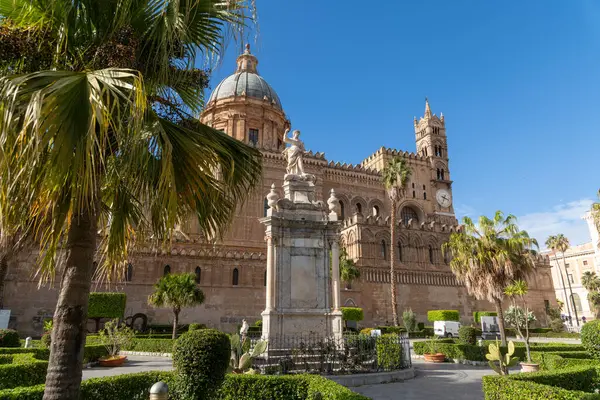 Palermo - Sizilien - Italien - 03-18-2025: Arka planda Palermo Katedrali 'nin kubbesi ve saat kulesi olan manikürlü bahçelerle çevrili mermer bir heykel görüntüsü