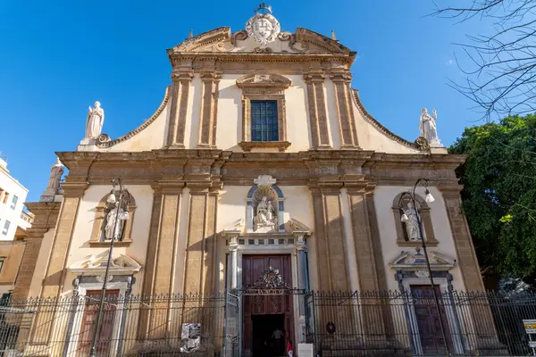 Palermo - Sizilien - Italien - 03-18-2025: Palermo 'daki bir Barok kilisesinin simetrik görüntüsü Chiesa del Gesu cephesi, dört heykeli, kemerli girişi ve açık mavi gökyüzü altındaki uzun sütunları.