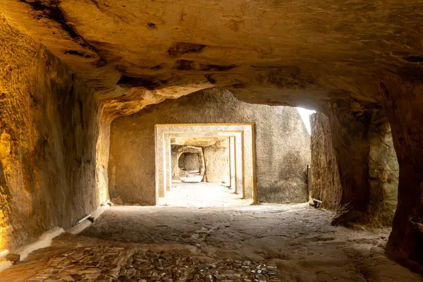 Sperlinga - Sizilien - Italien - 03-25-2025: Kabaca oyulmuş duvarları ve yumuşak ışık altında Burg Sperlinga, Sicilya 'nın derinliklerine uzanan birden fazla dikdörtgen taş çerçeveli kaya koridoru.