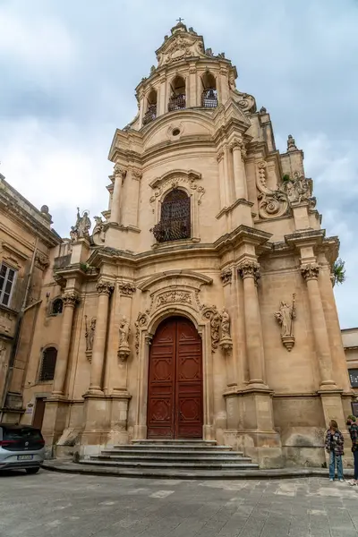 Ragusa, Sizilien - İtalya - 04-03-2025: Ragusa 'daki San Giuseppe Kilisesi' nin önünde ayrıntılı bir barok cephesi, süslü heykeller, kemerli kapılar ve taş basamaklar yer alıyor.
