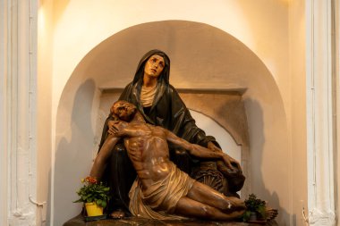 Scicli, Sizilien - İtalya - 04-05-2025: Scicli 'deki Madonna del Carmine kilisesinde aydınlatılmış bir niş içinde İsa' nın yasını tutan Bakire Meryem Heykeli.