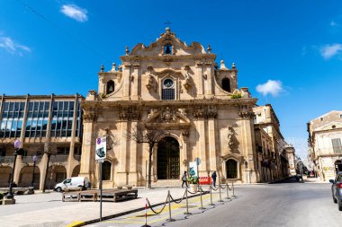 Scicli, Sizilien - İtalya - 04-05-2025: Scicli 'deki Loyola Kilisesi' nin Barok cephesi, heykeller, çan kuleleri ve parlak mavi gökyüzü arkaplanından oluşan ön manzarası.