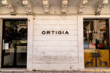 Scicli, Sizilien - İtalya - 04-05-2025: Scicli 'deki Ortigia mağazasının vitrininde dekoratif mozaik pencereler ve beyaz taş cephe altına mimari ayrıntılar kazınmış.