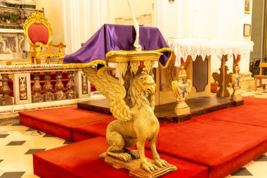 Noto, Sizilien - İtalya - 04-06-2025: Kilisenin içi, aslana benzeyen, mor kumaşla örtülü, süslü sunaklar ve kırmızı halılı basamaklarla çevrili bir minber..