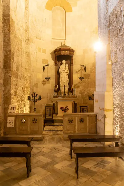 Pantalica, Sizilien - İtalya - 04-11-2025: Pantalica 'da güneşli bir yolda yeşil alanla çevrili Galleria Cascitita adlı taş tünelin girişine iki yürüyüşçü yaklaşıyor