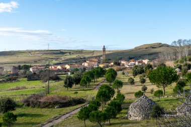 Semestene köyündeki bir kilise kulesi de dahil olmak üzere yeşil tarlaları, ağaçları ve geleneksel taş binaları olan kırsal bir arazi..