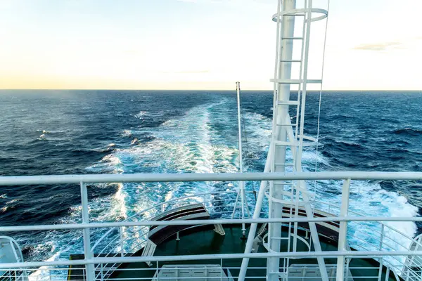 Üst güverteden, feribot yolculuğunun günbatımında açık okyanuslu beyaz korkulukları gösteren görüntüler..