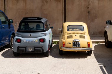 Syrakus, Sizilien - İtalya - 04-09-2025: Vintage sarı Fiat 500 ve modern gri Citroen Ami Syrakus 'ta yan yana park edilmiş, araba tasarımında belirgin bir kontrastı vurguluyorlar.