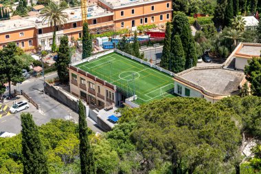 Taormina, Sizilien - İtalya - 05-04-2025: Taormina 'da ağaçlar ve binalarla çevrili bir çatı futbol sahası manzarası