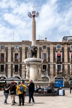 Catania, Sizilien - İtalya - 04-15-2025: Arka planda lav fil heykeli, dikilitaş ve barok binalar bulunan Sicilya 'daki Fil Çeşmesi etrafındaki turistler.