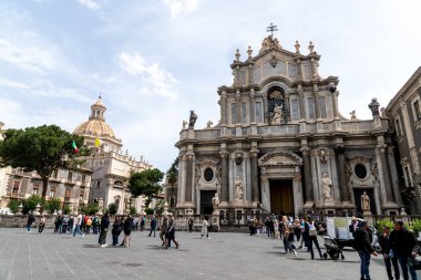 Catania, Sizilien - İtalya - 04-15-2025: Catania, Sicilya 'daki SantAgata Katedrali cephesi, barok heykeller, süslü sütunlar ve halk meydanında ziyaretçiler.