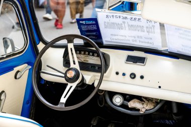 Taormina, Sizilien - İtalya - 05-04-2025: Direksiyon, hız göstergesi, gösterge paneli kontrolleri ve tur broşürlü klasik bir Fiat arabasının içi. Konum: Taormina, Sicilya.