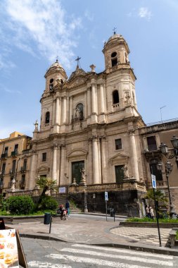 Catania, Sizilien - İtalya - 04-15-2025: Katanya, Sicilya 'daki SantAgata Katedrali' nin heykelleri, kemerli pencereleri, sütunları, ikiz kuleleri ve yayaları aşağıdaki.