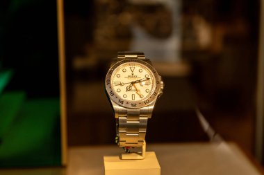 Taormina, Sizilien - İtalya - 05-04-2025: Paslanmaz çelik Rolex Explorer II, Sicilya 'nın Taormina kentinde bir bej standı üzerinde beyaz kadranlı ve siyah elli..
