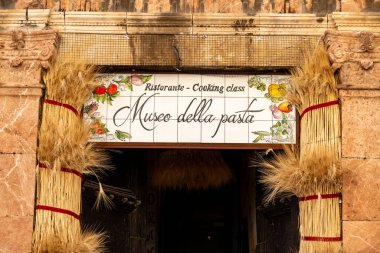 Taormina, Sizilien - İtalya - 05-04-2025: Sicilya 'nın Taormina kentindeki Museo della Pasta' nın girişi, buğday demetleri, boyanmış bir tabela ve oyulmuş mermer mimari ayrıntılar ile süslenmiş.