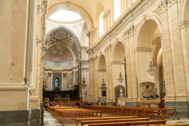 Catania, Sizilien - İtalya - 04-15-2025: Catania, Sicilya 'daki SantAgata Katedrali' nin sunak ve apse 'sine bakan naf, freskler, banklar ve yüksek kemerlerle.