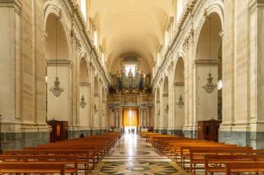 Catania, Sizilien - İtalya - 04-15-2025: Catania 'daki SantAgata Katedrali' nin ahşap sıraları, atlama tavanı, avizeleri, kemerleri ve uzak ucunda büyük bir boru organı bulunan görüntüsü.