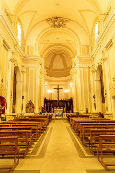 Catania, Sizilien - İtalya - 04-15-2025: Catania 'daki SantAgata Katedrali' nin merkezi koridoru boyunca tahta banklar, haçlar, avizeler ve kemerli tavan.