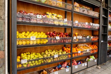 Taormina, Sizilien - İtalya - 05-04-2025: Bir dükkanın dışındaki plastik tepsilerde elmalar, armutlar, portakallar, limonlar ve atıştırmalıklar düzgünce düzenlenmiştir. Konum: Taormina, Sicilya.