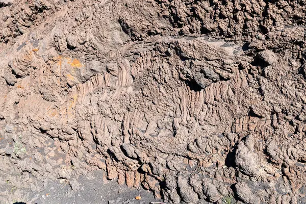 Sicilya 'daki Etna Dağı' nda katılaşmış lav yüzeyinin detaylı görüntüsü, kırmızımsı ve grimsi renklerle katmanlı, buruşuk dokuyu gösteriyor..