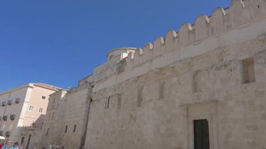 Syrakus, Sizilien - İtalya - 04-08-2025: Syracuse Katedrali 'nin yan görünüşü, taş duvara entegre edilmiş antik Doric sütunlarını ortaya çıkararak kökeni eski bir Yunan tapınağı olarak yansıtıyor.