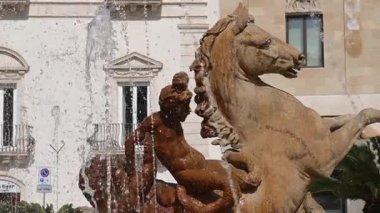 Syrakus, Sizilien - İtalya - 04-08-2025: Diana Fountain 'in yükselen atı ve efsanevi yaratığı ile yakın plan çekimi, su püskürtüleri tarihi binaların önünde gündüz vakti.