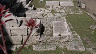 Syrakus, Sizilien - İtalya - 04-08-2025: Syracuse 'deki Porta Urbica' nın antik taş blokları ve temelleri, kentsel duvarlar ve kısmen görünür şehir binalarıyla çevrili.