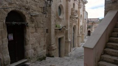 Ragusa, Sizilien - İtalya - 04-03-2025 Redaktionell: Santa Maria dellItria 'nın barok cephesini ve Ragusa İbla' nın dar bir sokağındaki mimariyi gözler önüne seren yavaş tava.