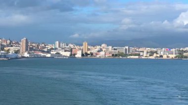 Cagliari - Sardinien - Italien - 03-15-2025: Cagliari 'nin feribottan panoramik manzarası, tepeler, konut binaları, marina ve önde gelen bir kiliseyi gösteriyor