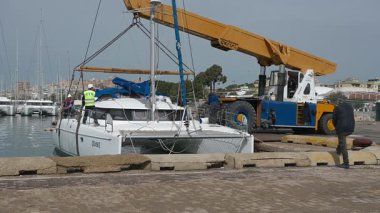 Cagliari - Sardinien - Italien - 03-14-2025: Mürettebat pozisyonları ve vinç güpegündüz liman kenarına yanaşmaya hazırlanıyor.
