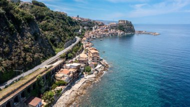 Scilla - Kalabrien - 05-27-2025: Scilla, Calabria 'daki uçurum kenarındaki evler, yol ve kale açık deniz ve eski kasaba boyunca gün ışığında uzanıyor.