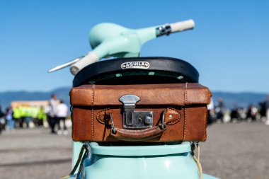 Reggio Calabria - Kalabrien - 05-18-2025: Deri bavul Nane yeşili bir scooter 'a bağlanmış Reggio Calabria' daki Seçkin Beyefendiler Arkasından görüldü.
