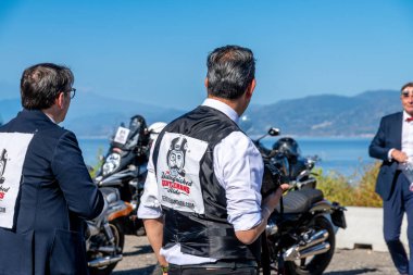 Reggio Calabria - Kalabrien - 05-18-2025: Reggio Calabria 'daki Seçkin Centilmenler Turuna katılanlar üzerinde etkinlik logoları olan yeleklerle motosikletler ve sahil şeridinde duranlar.