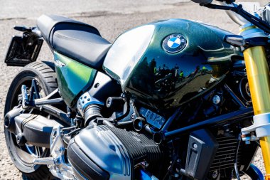 Reggio Calabria - Kalabrien - 05-18-2025: Koyu yeşil bir BMW R12 motorsiklet yakıt tankının açık görüntüsü, insanları ve yüksek parlaklıktaki çevreyi yansıtıyor.