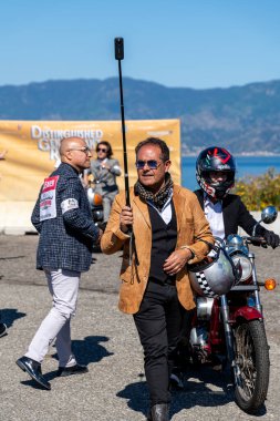 Reggio Calabria - Kalabrien - 05-18-2025: Klasik giysiler ve miğferler içindeki çok sayıda erkek klasik motosikletle Üstün Beyefendiler 'e katılıyor.