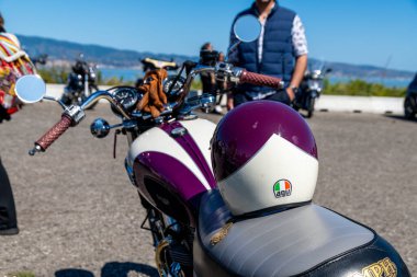 Reggio Calabria - Kalabrien - 05-18-2025: Kahverengi eldivenli ve AGV kasklı klasik motosiklet.