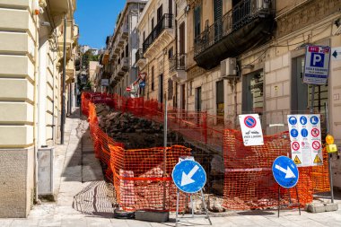 Reggio Calabria - Kalabrien - 05-22-2025: Reggio Calabria 'da dik bir cadde turuncu eskrim ve inşaat için yol tabelalarıyla kapatıldı.