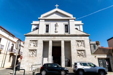 Reggio Calabria - Kalabrien - 05-22-2025: Reggio Calabria 'da Chiesa del Santo Rosario, haç, sütunlar, rahatlamalar ve vitraylı pencereler, park halindeki arabaların olduğu sokaktan görülüyor