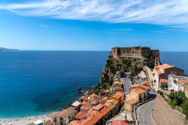 Scilla - Kalabrien - 05-27-2025 Castello Ruffo di Scilla 'nın deniz üzerindeki bir uçurumun manzarası, kıyı evleri ve kalenin altında uzanan bir plaj..