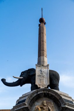 Catania, Sizilien - İtalya - 04-15-2025: Catania, Sicilya 'daki Fil Çeşmesi' nde üzerinde açık mavi bir gökyüzü altında görünen siyah bir lav fil heykeli yer alıyor..