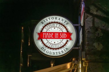 Tropea - Kalabrien - İtalya - 05-30-2025: Sud 'da Yapılan Restoran tabelası Tropea, Calabria, İtalya' da bir sokakta geceleyin aydınlatılıyor ve yerel bir lokantayı işaret ediyor.