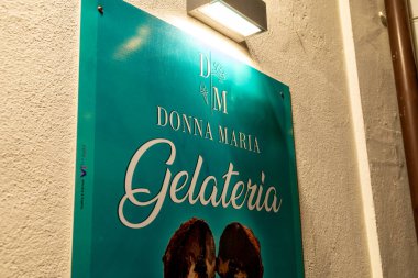 Tropea - Kalabrien - İtalya - 05-30-2025: İtalya 'nın Calabria bölgesinde yer alan Tropea kasabasının dış duvarına Donna Maria Gelateria için ışıklı bir işaret asıldı.