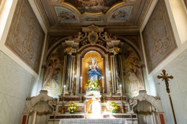 Pizzo - Kalabrien - İtalya - 06-02-2025: İtalya 'nın Pizzo kentindeki Saint Mary Immaculate Kilisesi' nde, melek freskleri ve sütunlarıyla çevrili Bakire Meryem heykeli ile süslü sunak.