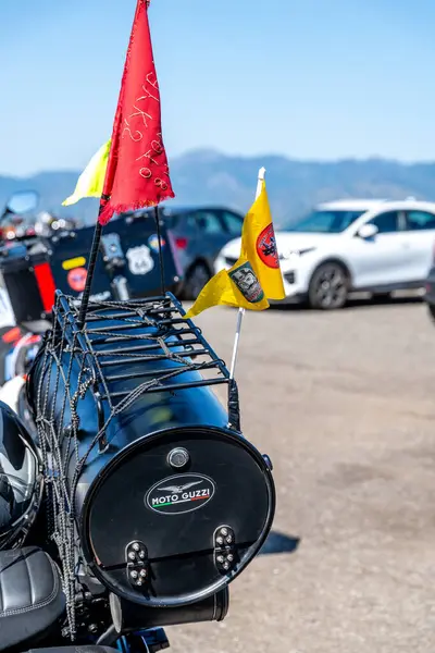 Reggio Calabria - Kalabrien - 05-18-2025: Reggio Calabria 'daki Üstün Centilmen Turu sırasında çekilen fıçı çantalı ve bayraklı Moto Guzzi motosikletinin arka görüntüsü.