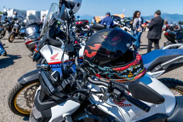 Reggio Calabria - Kalabrien - 05-18-2025: Renkli miğferi ve ön camlı Honda motosikleti güneşli bir günde İtalya 'nın Reggio Calabria şehrinde düzenlenen Üstün Beyefendiler Turu sırasında park edildi.